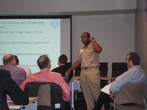 Cmdr. Patrick Mack, USN, commanding officer, Space and Naval Warfare Systems Command PMW-150, addresses the chapter at its December meeting.